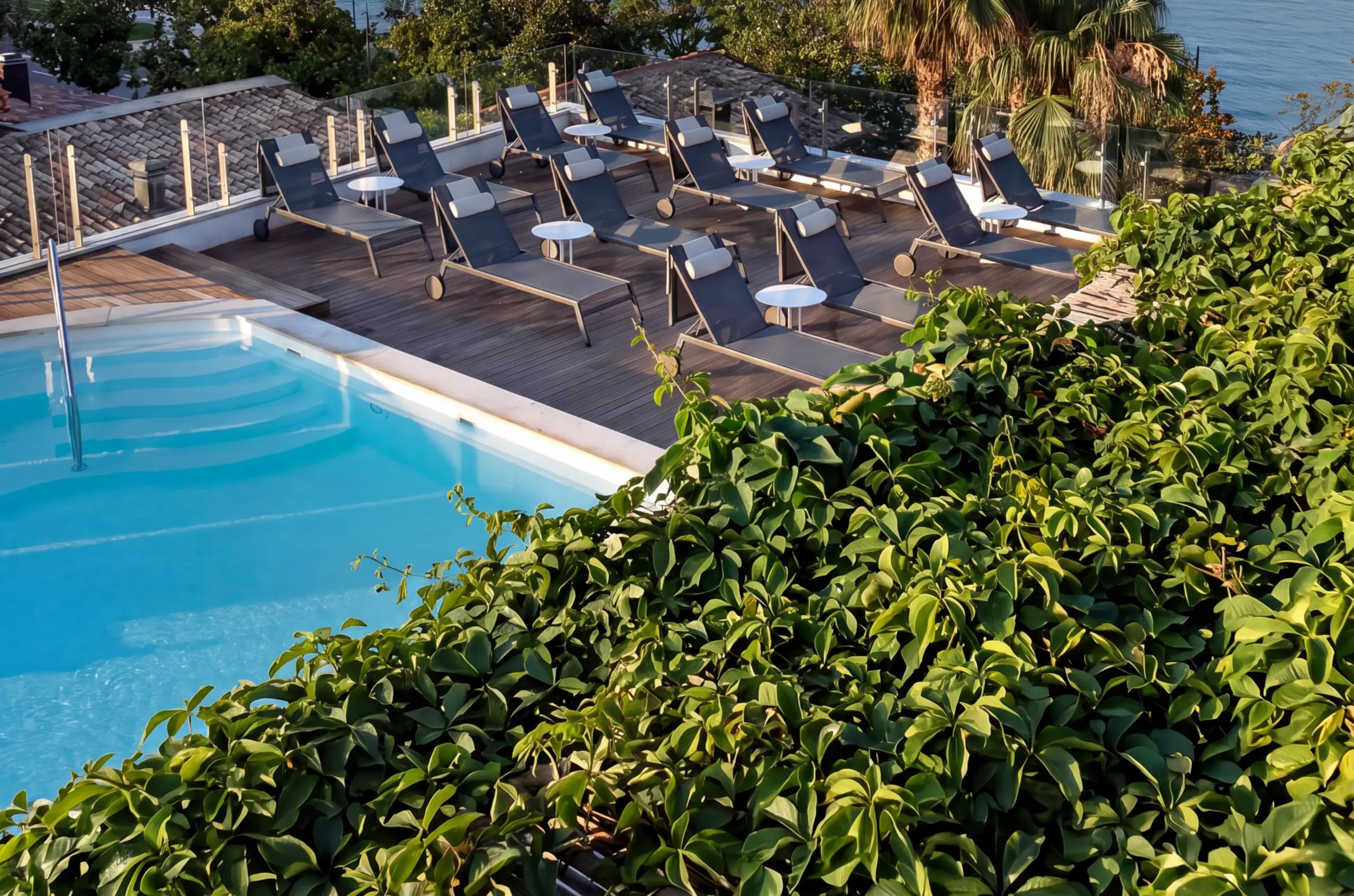 pool with sun loungers and greenery at Park Hotel Desenzano
